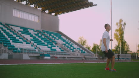 Set-the-socker-ball-on-the-lawn-run-and-hit-the-ball-in-the-stadium-with-a-green-lawn.-A-professional-soccer-player-kicks-the-ball-in-slow-motion